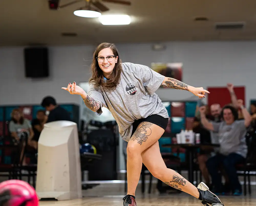 Smiling woman mid-delivery in her bowling follow-through at Bel-Air Bowl in Belleville, IL - Bowling Leagues