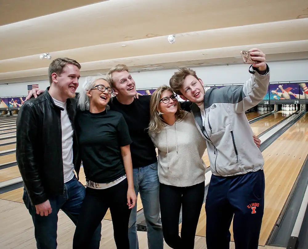 Group of co-workers posing for a selfie in front of the lanes at Bel-Air Bowl in Belleville, IL - Team Building events