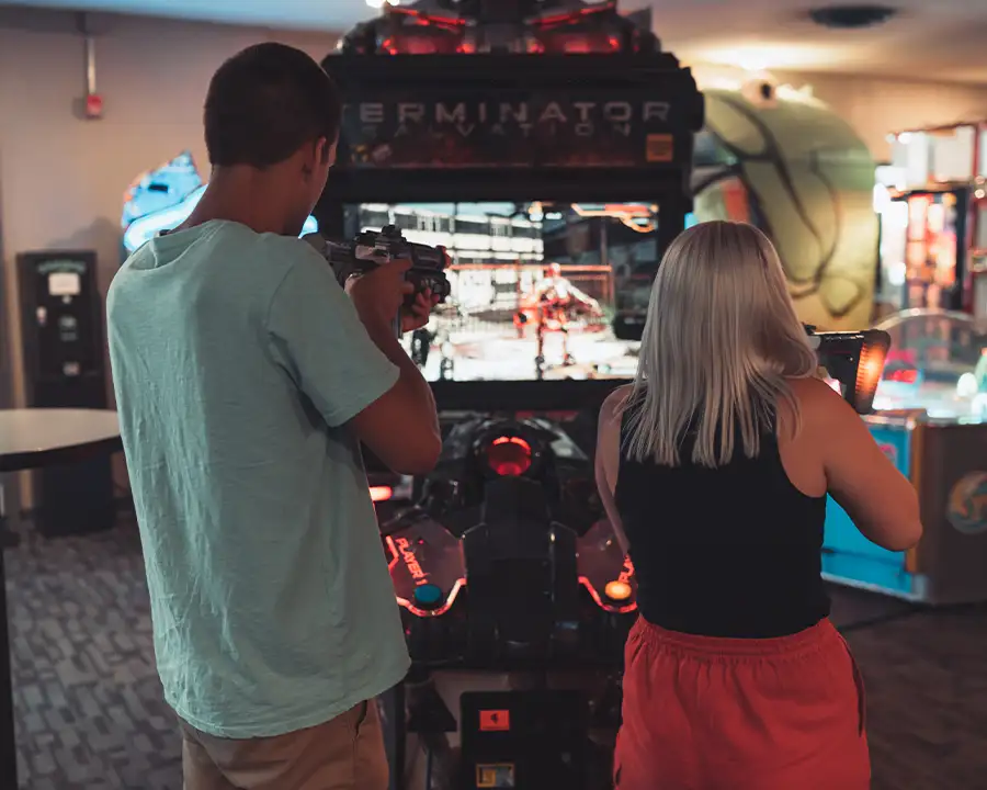 Man and woman aiming gun controllers at the Terminator Salvation arcade game at Bel-Air Bowl in Belleville, IL