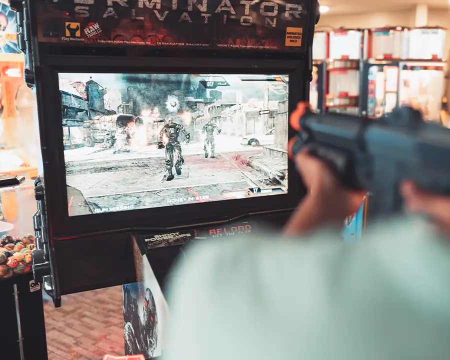 Terminator Salvation arcade screen with a player aiming a gun controller at Bel-Air Bowl in Belleville, IL