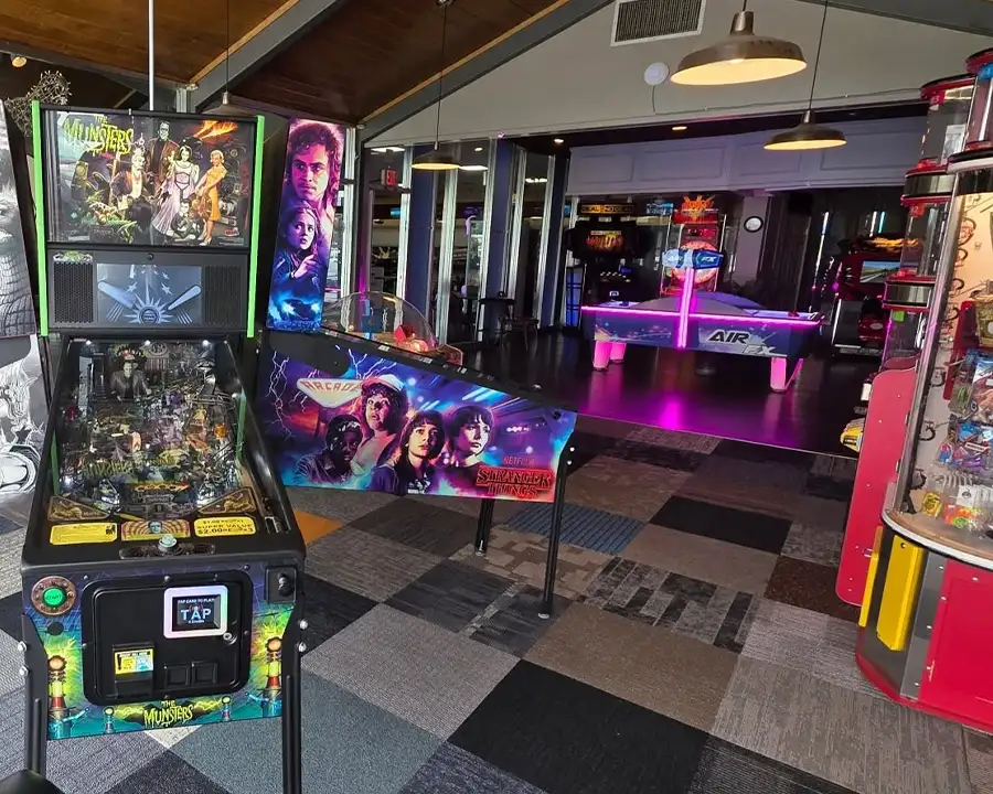Munsters and Stranger Things pinball machines near an air hockey table - Arcade Games at Bel-Air Bowl in Belleville, IL